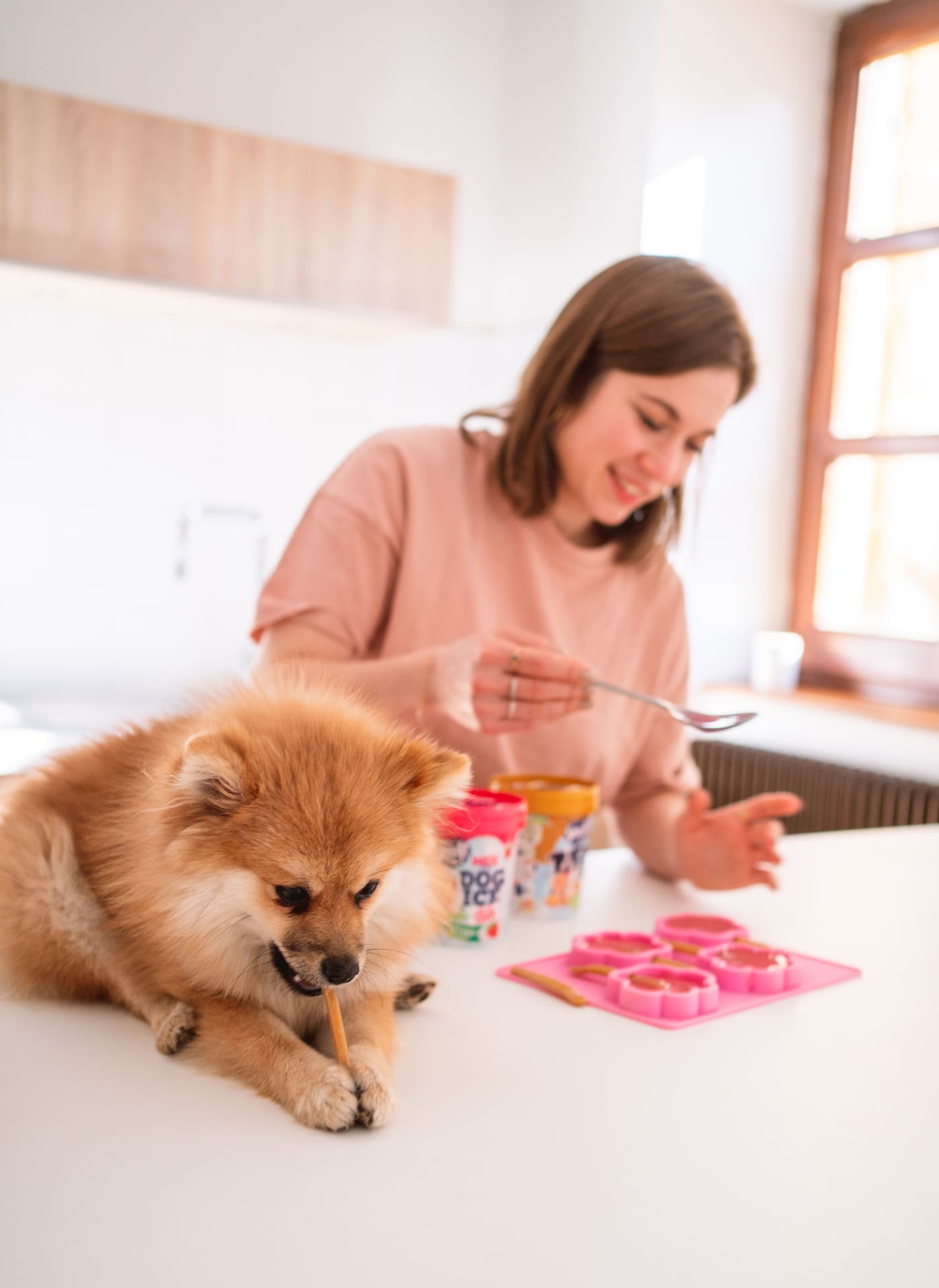 Girl and pomeranian making Smoofl ice cream for dogs